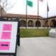 A sign in English and Spanish directs patients to check-in for covid-19 vaccination appointments at the Yakima Valley Farm Workers Clinic in Toppenish, Washington